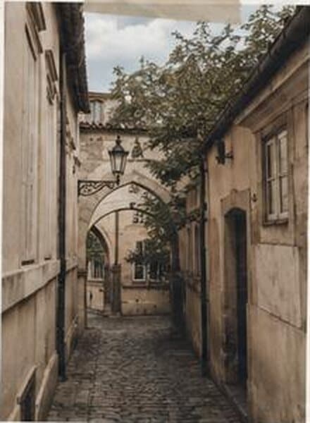 A narrow cobbled street in Prague with an old lantern.
